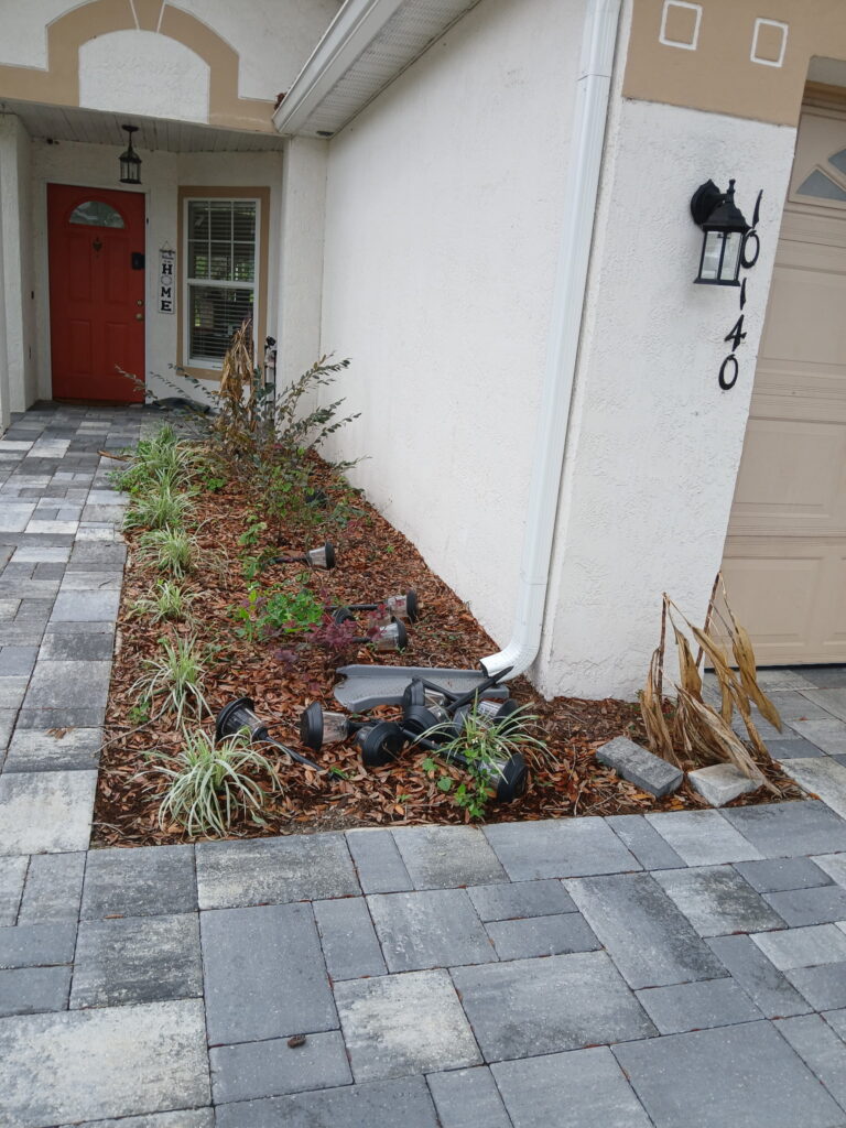 Before decorative rock landscaping with a small front planting bed beside a walkway